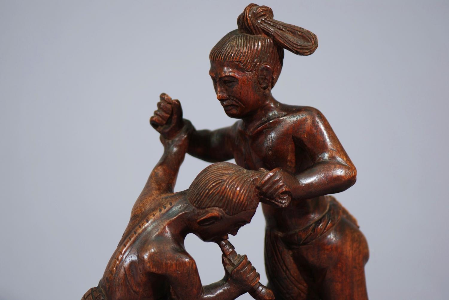 Hardwood carving of two wrestlers
