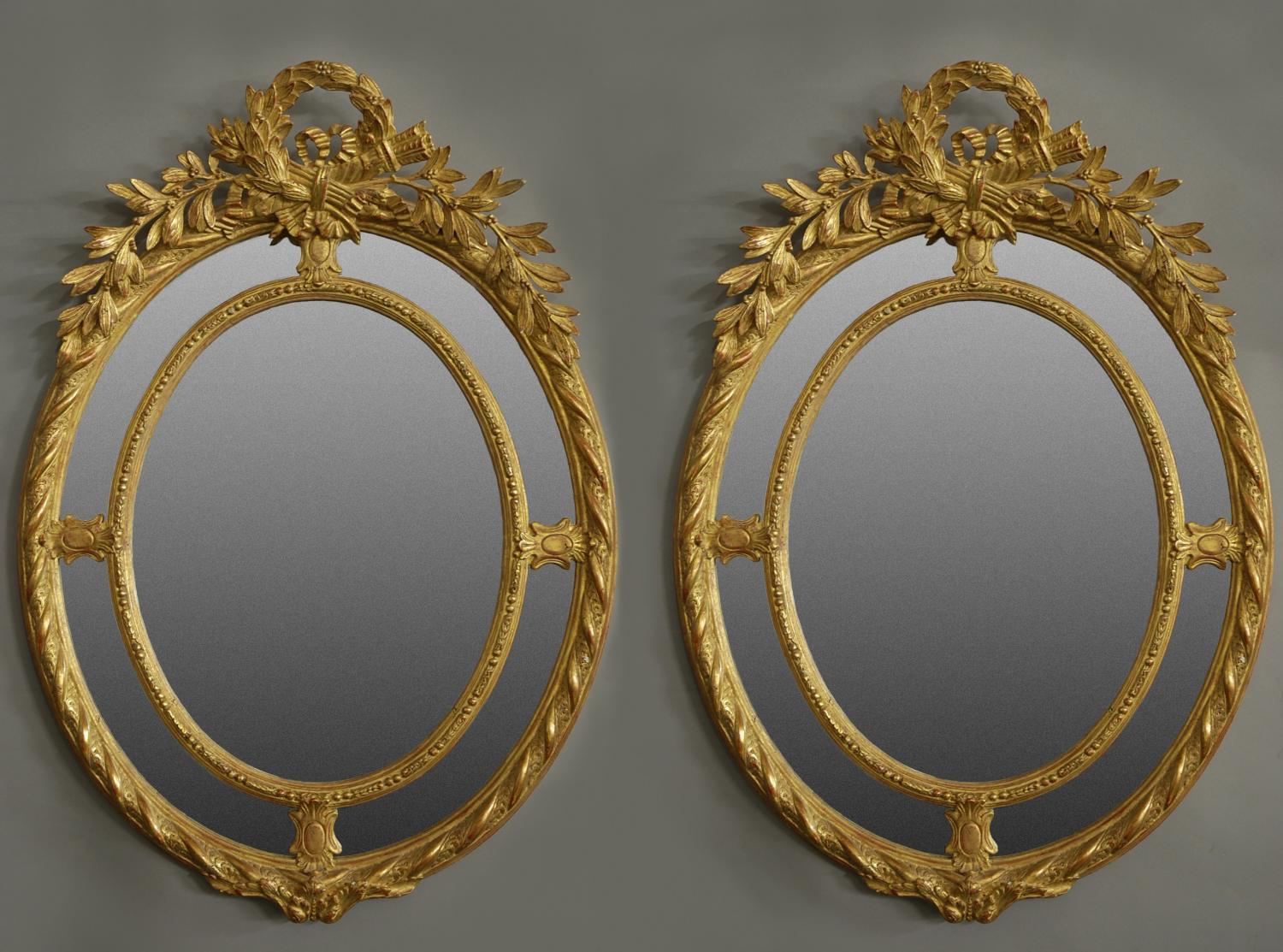 Pair of highly decorative oval gilt mirrors
