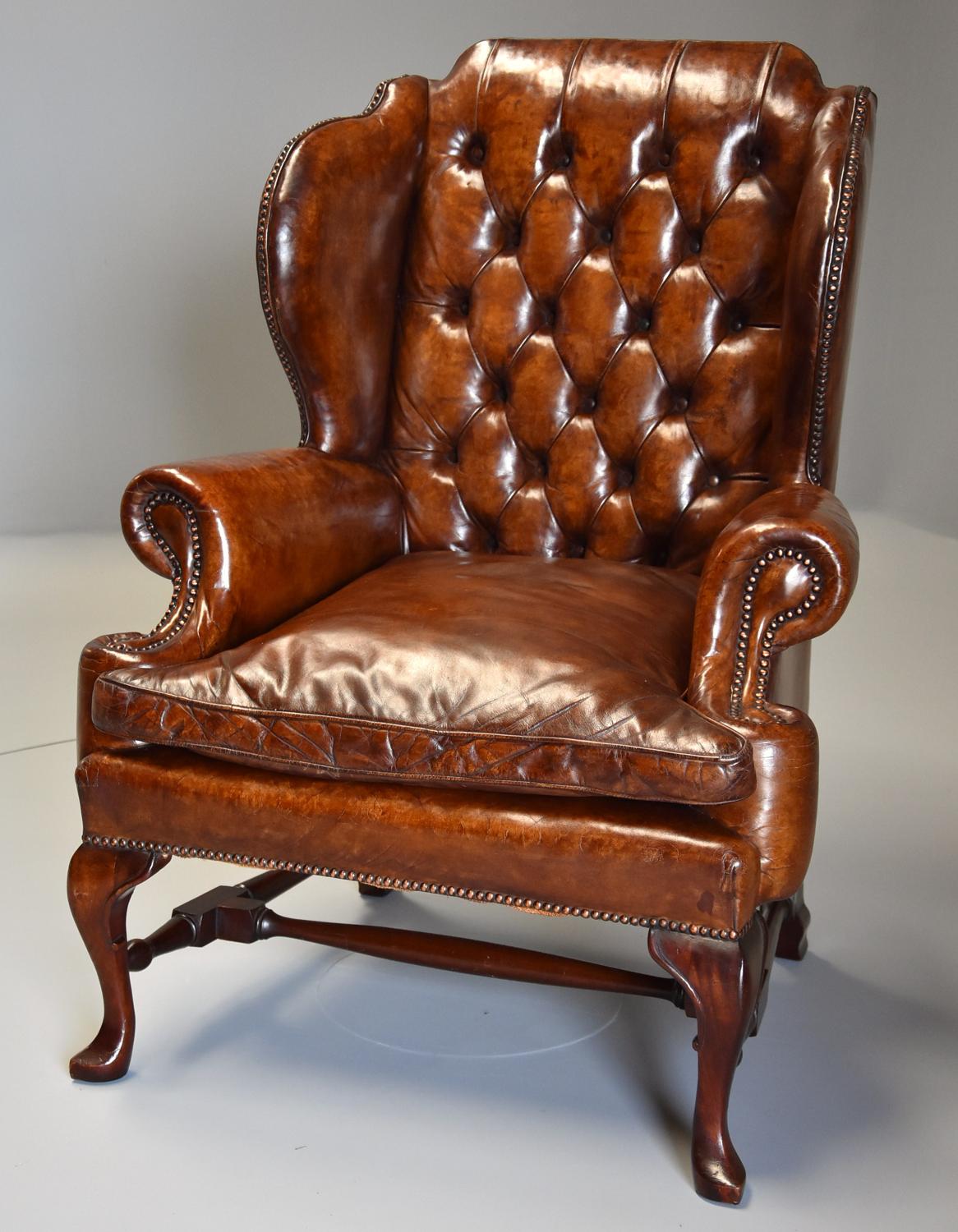 Early 20thc Georgian style deep buttoned brown leather wing armchair