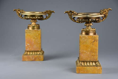 A pair of gilt metal tazzas on marble bases in the Neoclassical style