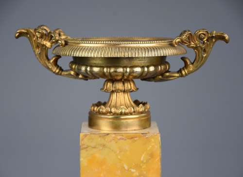 A pair of gilt metal tazzas on marble bases in the Neoclassical style