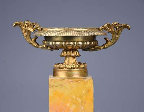 A pair of gilt metal tazzas on marble bases in the Neoclassical style