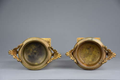 A pair of gilt metal tazzas on marble bases in the Neoclassical style